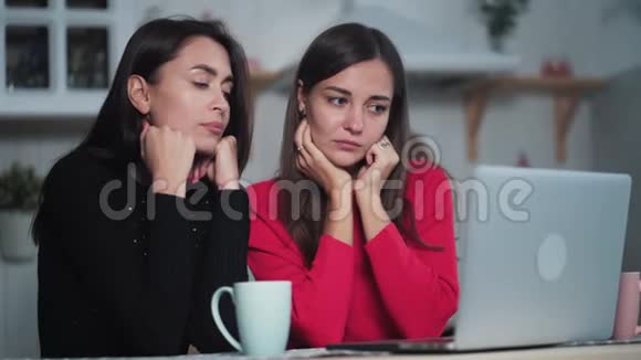 无聊的年轻女性朋友在家里用笔记本电脑看视频讨论这个问题视频的预览图