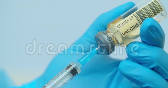 医生他的手把注射器装满疫苗为注射给病人做准备双手并拢视频的预览图