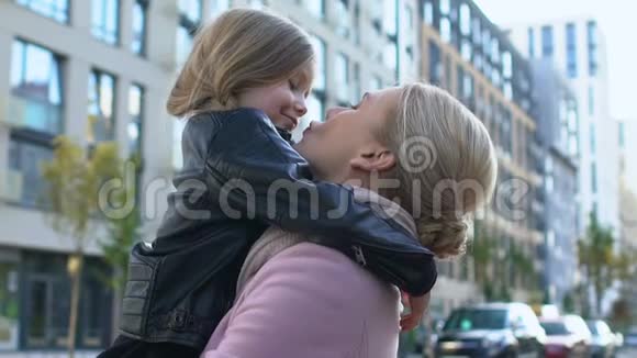 母亲亲吻女儿的鼻子抱着孩子家庭爱的表情温柔视频的预览图