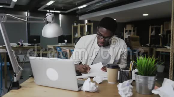 厌倦了在办公桌前工作的非裔美国商人视频的预览图