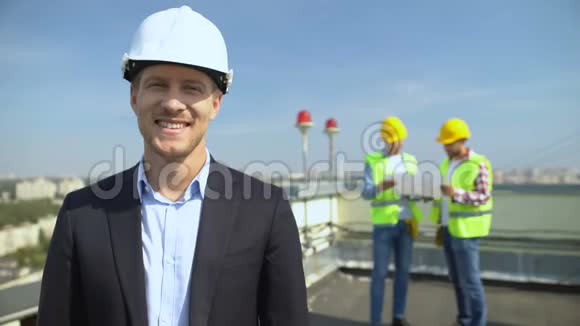 戴着安全帽的建筑工程师微笑着看着摄像机熟练的建筑师视频的预览图