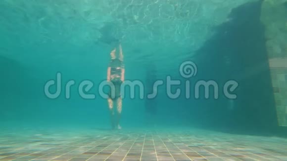 慢动作水下拍摄一对幸福的夫妇在游泳池里潜水他们在水下跳舞0健康视频的预览图