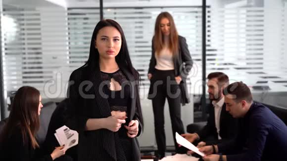 一位性感的商业女性身后有员工在看摄像机视频的预览图