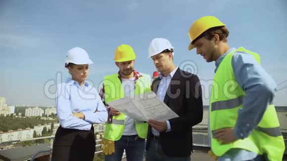 建筑工程师手持建筑图向工人讲解安全帽视频的预览图