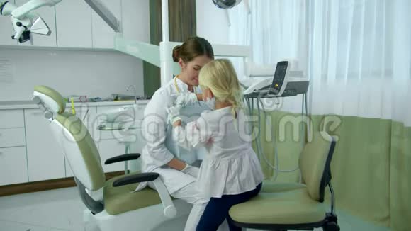 女孩从牙医那里取出尿布他们握手视频的预览图