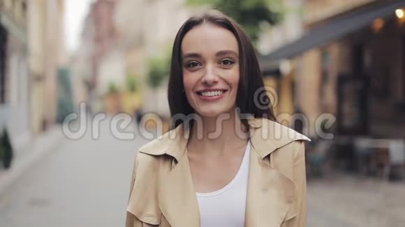 美丽的白种人年轻女孩站在城市街道的尽头看上去快乐满意微笑和欢笑视频的预览图