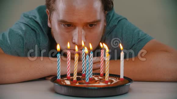 悲伤的人正在吹灭生日蛋糕上的蜡烛视频的预览图