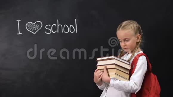 顽皮的女学生拿着书站在黑板旁我喜欢写字的学校视频的预览图