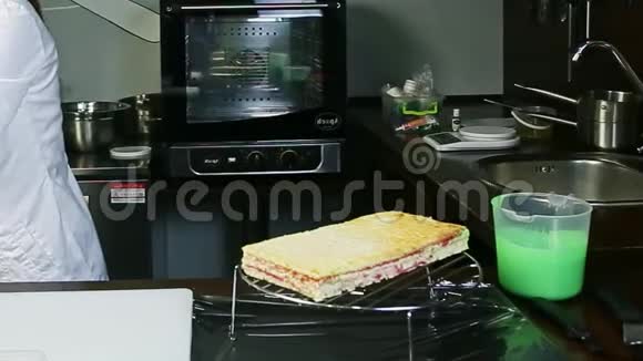 在金属支架上的分层蛋糕上倒入彩色绿色釉视频的预览图