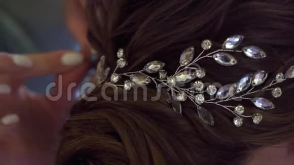 珠宝在头发装饰发型的女人理发师在婚礼上和黑发新娘一起工作视频的预览图