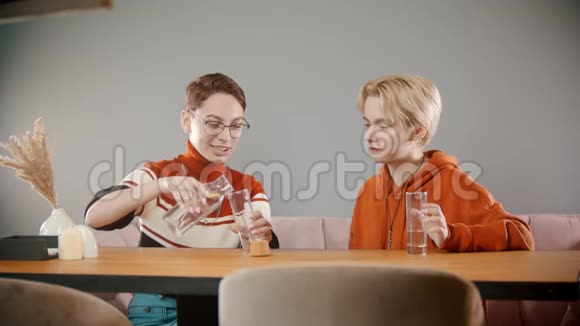 戴眼镜的女孩正在往玻璃杯里倒水视频的预览图