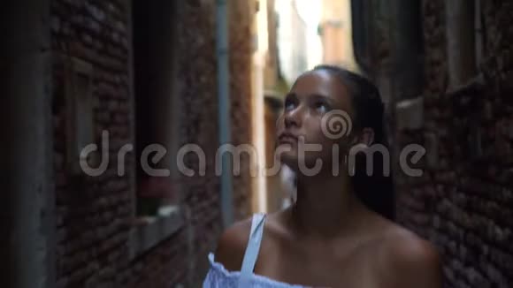 可爱的女孩走路看威尼斯老街墙特写视频的预览图