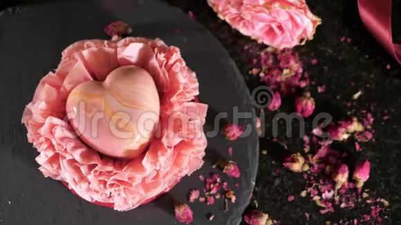 五颜六色的甜点在心形的桌子上用鲜花特写视频的预览图