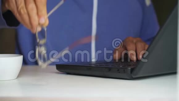 老人把手提电脑的近景放在一边视频的预览图