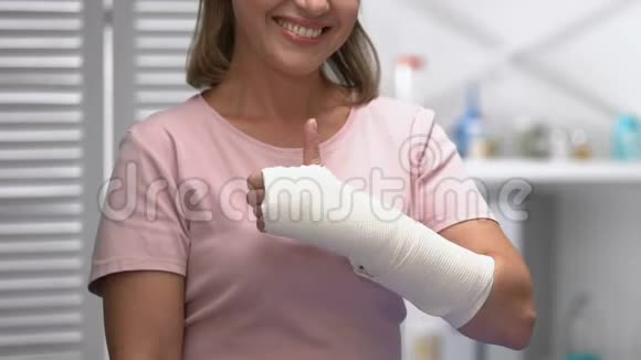 手臂弹力绷带微笑的妇女竖起大拇指医生检查视频的预览图
