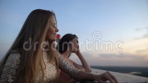 美丽的女性朋友在露台上欣赏日落宁静视频的预览图