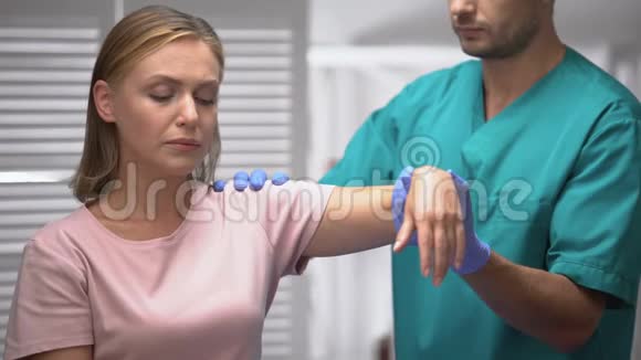 外科医生检查创伤后悲伤病人的肩膀举起女性的手康复视频的预览图