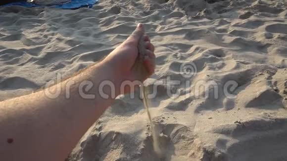 从一个人手中沙子在海滩上视频的预览图