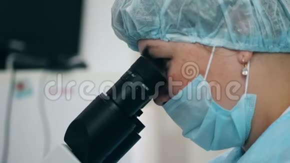 一位妇女在医院用显微镜工作视频的预览图