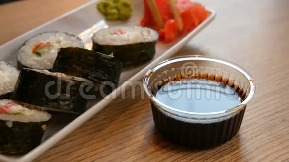 大寿司卷三文鱼在诺里螃蟹棒黄瓜费城奶酪蘸酱油碗视频的预览图