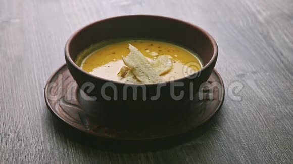 用蘑菇和干面包装饰的黄色奶油汤做全景视频的预览图