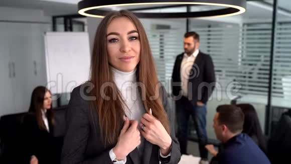 女商人站在一座现代化的办公楼里同事在后台视频的预览图