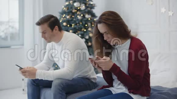 忙碌的家庭在私人住宅里寻找智能手机已婚夫妇使用电话视频的预览图