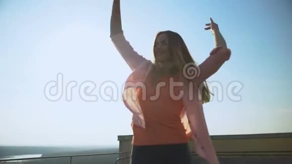 美丽的微笑女人享受生活在摩天大楼屋顶上跳舞放松视频的预览图