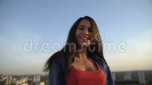 女模特在屋顶上拍照拍摄城市景色视频的预览图