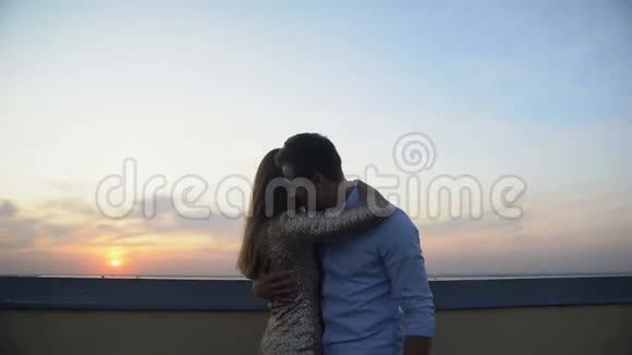 在屋顶上跳舞的情侣日落时的浪漫约会恋情视频的预览图