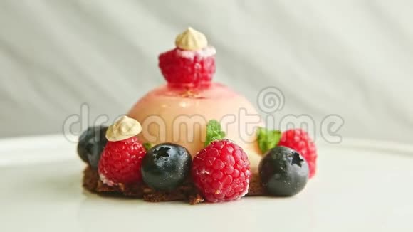 特写粉色糖霜甜点精心装饰浆果旋转在盘子上视频的预览图