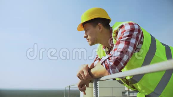 青年工人斜靠建筑栏杆站在户外建筑职业视频的预览图
