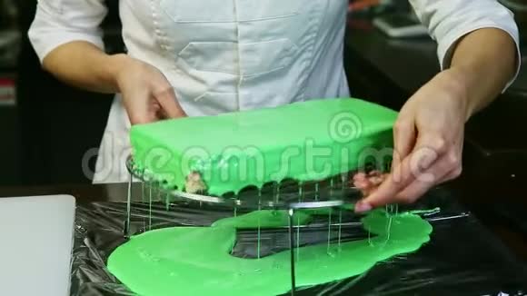糖果师从金属支架上的分层蛋糕中取出青釉剩菜视频的预览图