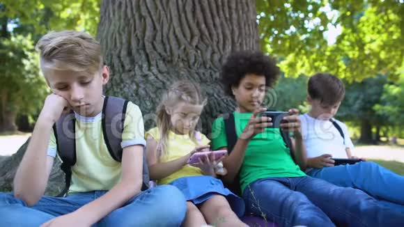 当朋友在手机上玩游戏而不是交流时男孩感到无聊视频的预览图
