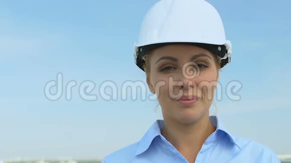 有经验的女建筑师戴着安全帽相机微笑服务良好视频的预览图