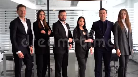 一群成功的商人在办公室里站在一起视频的预览图