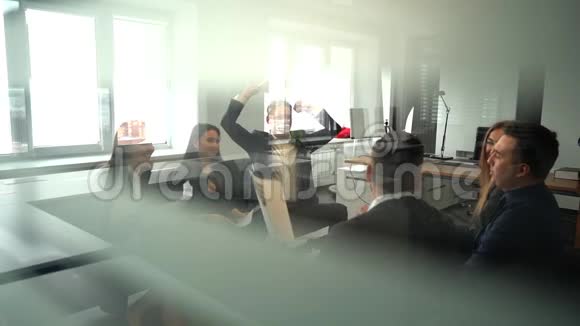 工作人员在办公室里扔纸和微笑慢动作透过玻璃射击视频的预览图
