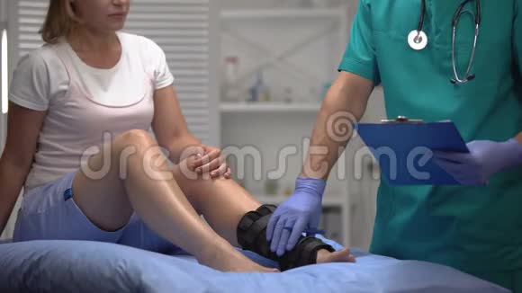有经验的骨科医生检查病人腿部的踝关节支撑填写文件视频的预览图