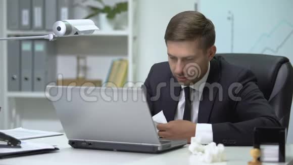 生病的商人在办公室里用笔记本电脑打喷嚏流感视频的预览图