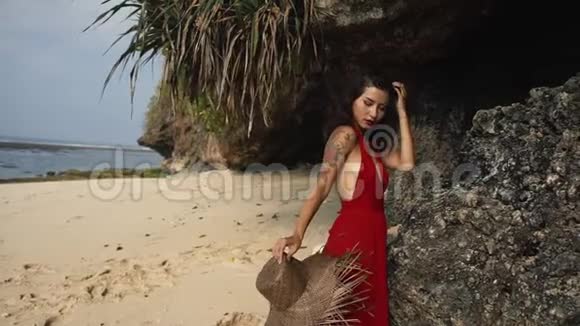 海滩上穿着红色连衣裙的快乐美女美容旅游时尚理念视频的预览图