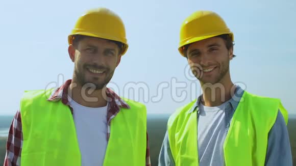 有经验的男建筑工人戴着头盔穿着制服对着镜头微笑服务良好视频的预览图