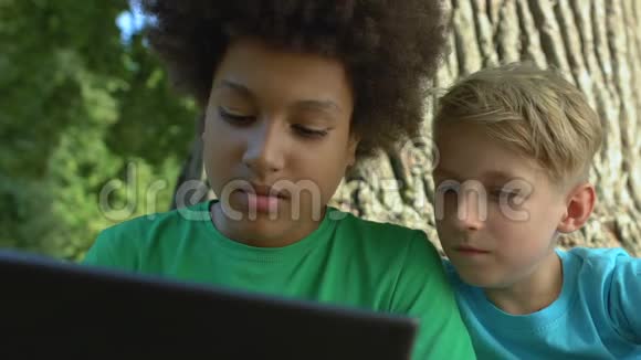 男性朋友一起坐在户外滚动平板电脑应用科技视频的预览图