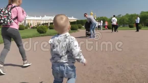 快乐可爱的男孩在绿色公园为妈妈跑他的姐姐在旁边跑家庭观念视频的预览图