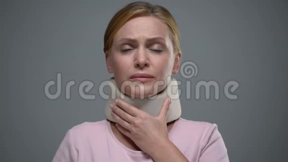 泪流满面的女人抚摸脖子上的颈圈颈椎外伤视频的预览图