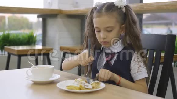 穿校服的小女孩在学校食堂吃午饭视频的预览图