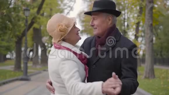 微笑成熟的白种人夫妇在秋天公园的小巷里跳舞积极的高级家庭在户外约会视频的预览图
