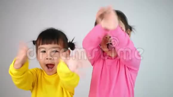 一张快乐微笑的兄弟姐妹的肖像女孩挥手告别孤立在白色的背景上视频的预览图