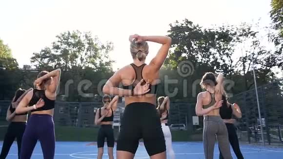不可辨认的年轻运动女性在健身训练中背着胳膊的背影视频的预览图