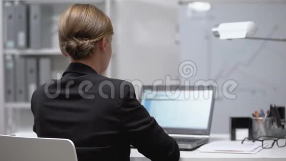 疲惫的女人按摩麻木的脖子工作笔记本电脑掐神经后视视频的预览图