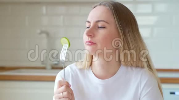 沮丧的节食女人在盘子里吃黄瓜视频的预览图